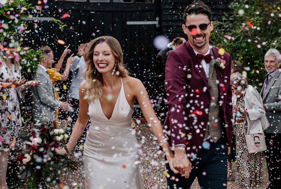 Newly married couple having confetti thrown on them