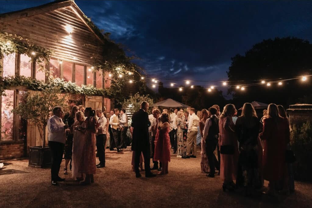 Guests celebrating at a rustic barn wedding reception at High Billinghurst Farm.
