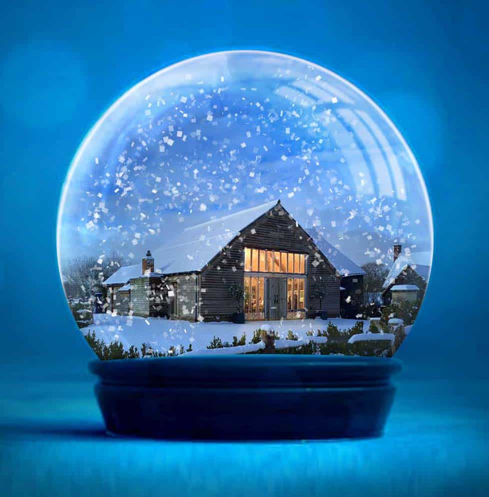 Creative snow globe image of High Billinghurst Farm, a Surrey barn wedding venue in winter with snow and fairy lights